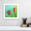 Framed painting of discus fish hanging on a wall.