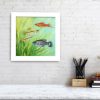 Swordtail fish painting in white frame hanging on a wall.