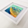 Cichlid painting in a white frame.